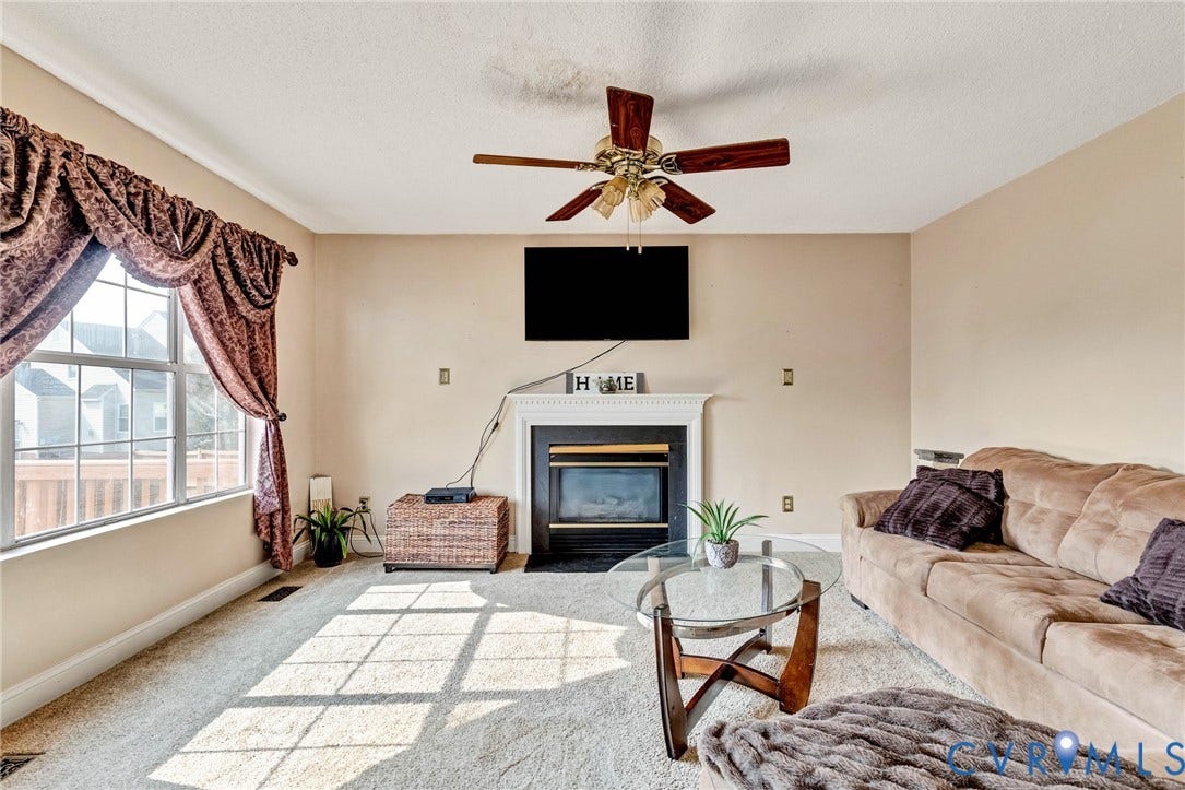1601 Varina Station Court, Henrico, VA 23231 Carpeted living area featuring a ceiling fan, fireplace with a white mantel, and a large window
