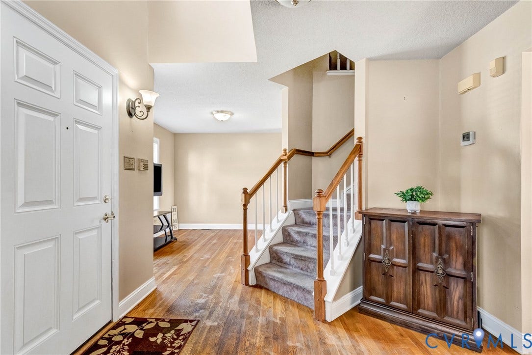 1601 Varina Station Court, Henrico, VA 23231 Entryway featuring a paneled door, wood-finish flooring, and a carpeted staircase with wood handrails