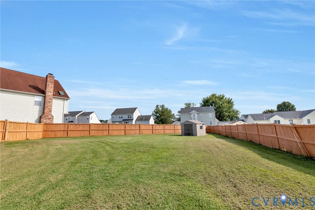 1601 Varina Station Court, Henrico, VA 23231 Expansive green lawn fully enclosed by a new wooden privacy fence, featuring a storage shed