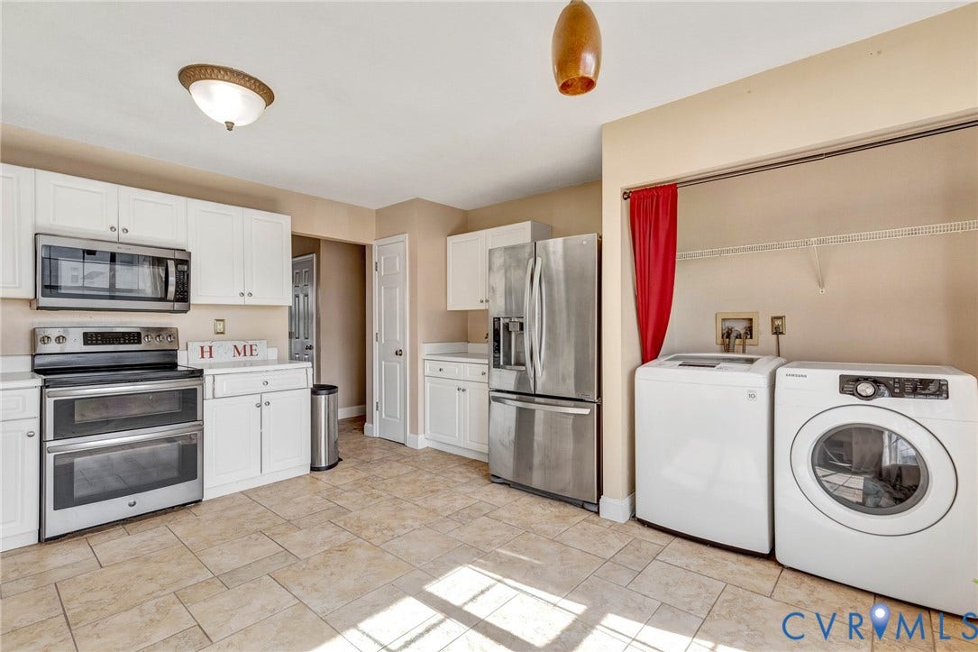 1601 Varina Station Court, Henrico, VA 23231 White cabinetry, stainless steel appliances, tile flooring, and integrated laundry area with shelving