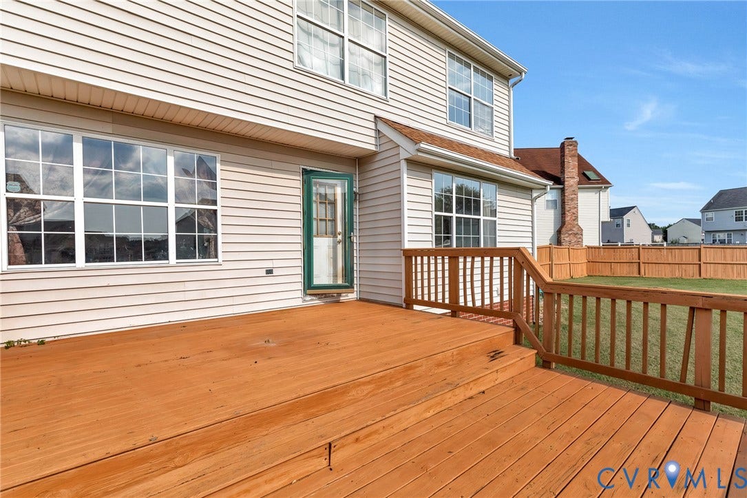 1601 Varina Station Court, Henrico, VA 23231 Expansive wood deck with railing and stairs, featuring vinyl siding and multiple windows