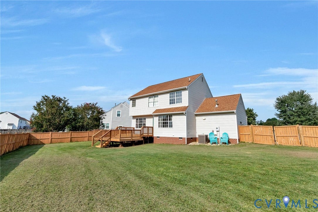 1601 Varina Station Court, Henrico, VA 23231 Expansive grassy yard with a full privacy fence, elevated wood deck, and white vinyl siding