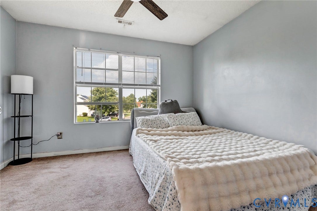 1601 Varina Station Court, Henrico, VA 23231 Carpeted flooring, light blue painted walls, ceiling fan, and a large window with blinds
