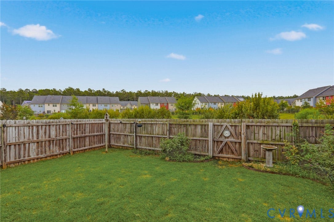 10653 Braden Parke Drive, Midlothian, VA 23832 Fenced backyard featuring a manicured lawn, wood privacy fencing, and mature perimeter landscaping