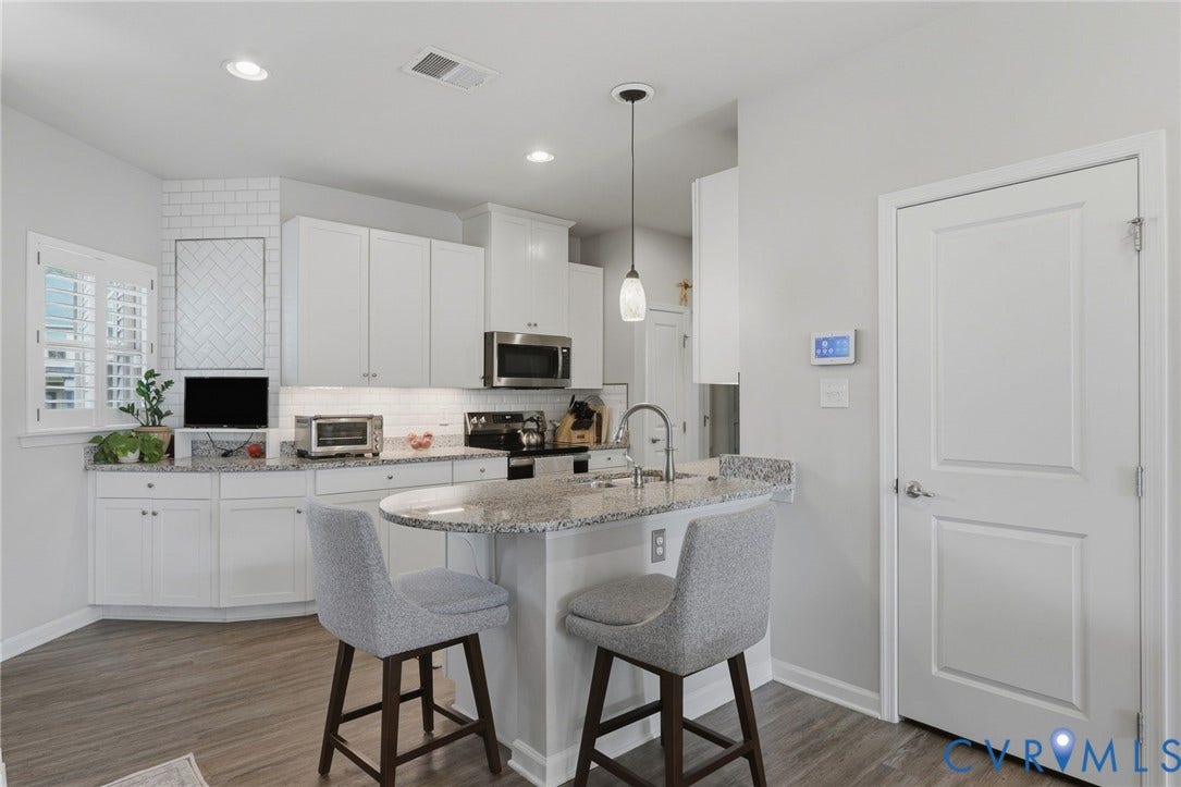 10653 Braden Parke Drive, Midlothian, VA 23832 Contemporary kitchen featuring white cabinetry, wood-finish flooring, recessed lighting, and a granite island with a built-in sink