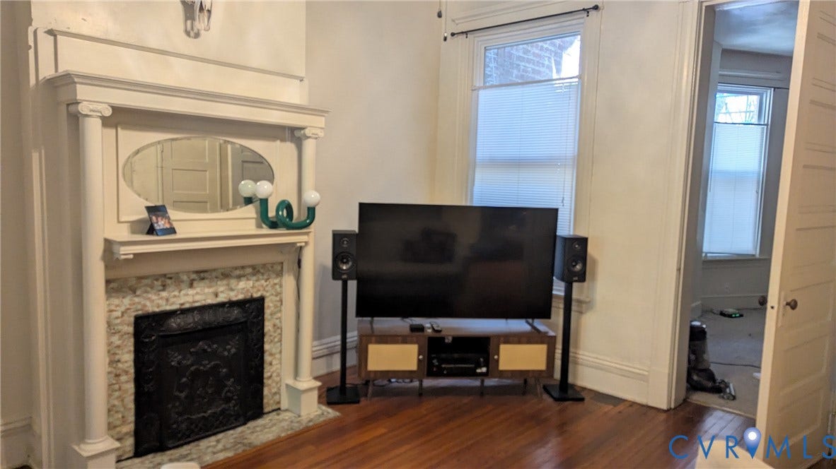 1620 Grove Avenue, #1, Richmond, VA 23220 Ornate fireplace surround featuring a decorative mantel with an oval mirror insert, stone-finish tile hearth, and dark metal firebox