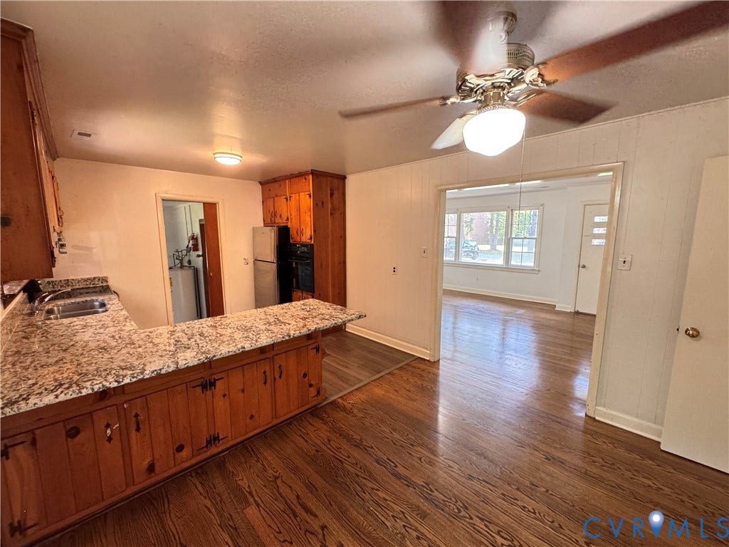Kitchen area featuring wood-finish flooring, a breakfast bar with a speckled countertop, and wood cabinetry
