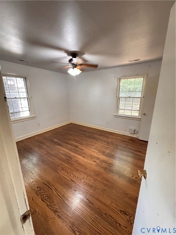 Room featuring wood-finish flooring, white walls, and a ceiling fan with integrated lighting