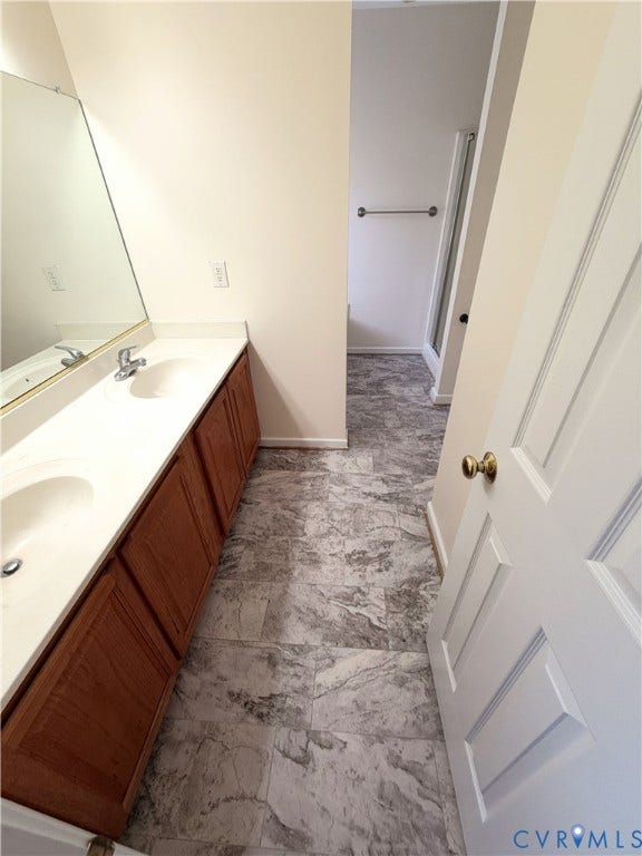 Dual sink vanity with wood-finish cabinetry and light-toned countertops