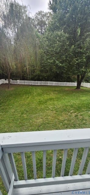 Expansive grassy yard with white picket fencing, mature trees, and a painted wood railing