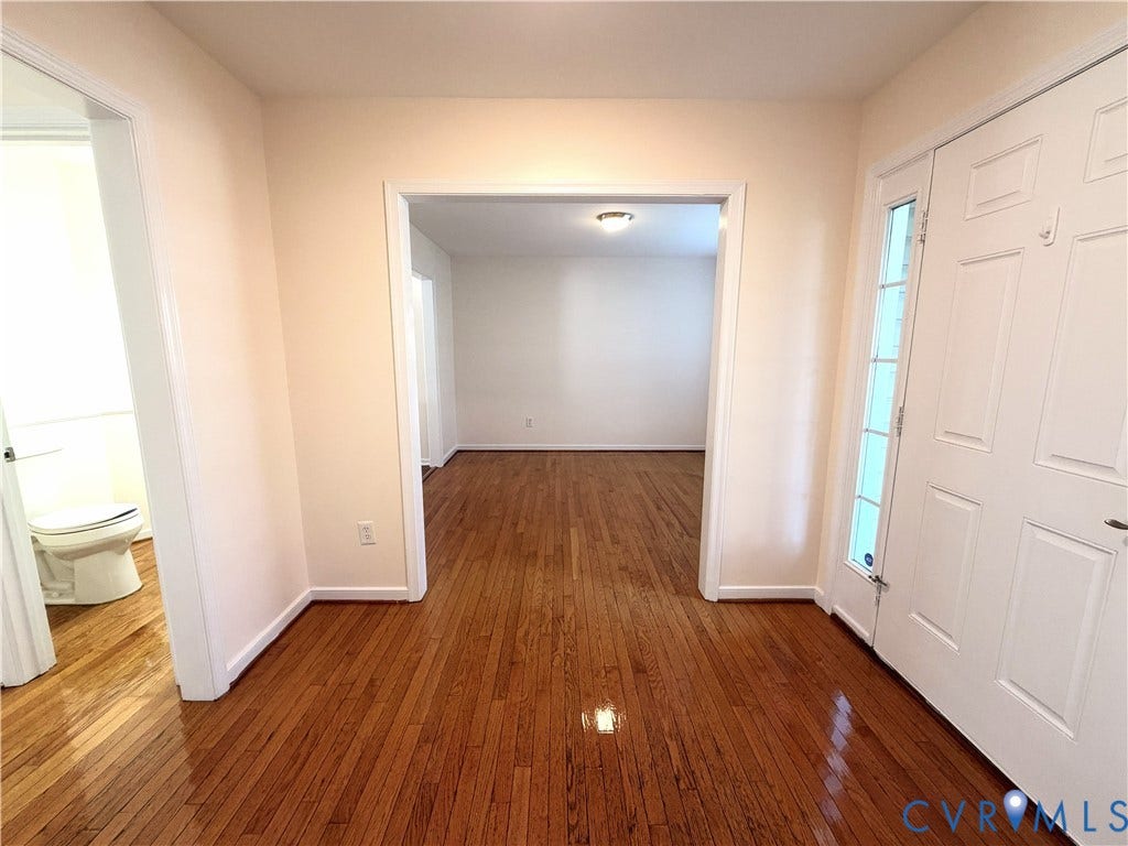 Hardwood flooring throughout, white interior doors, and neutral wall paint