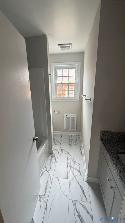 207 Mac Arthur Avenue, Gregory, Colonial Heights, VA 23834 Contemporary bathroom featuring an integrated tub/shower combination, white vanity with a speckled countertop, and white tile flooring with dark veining