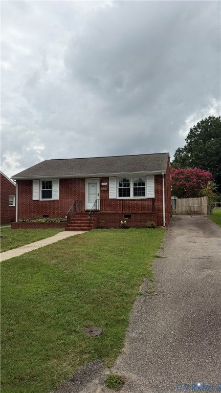 207 Mac Arthur Avenue, Gregory, Colonial Heights, VA 23834 Brick facade home featuring a front porch with railing, white shutters, and an asphalt driveway