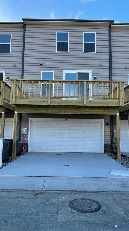Back of house featuring central AC unit and a garage
