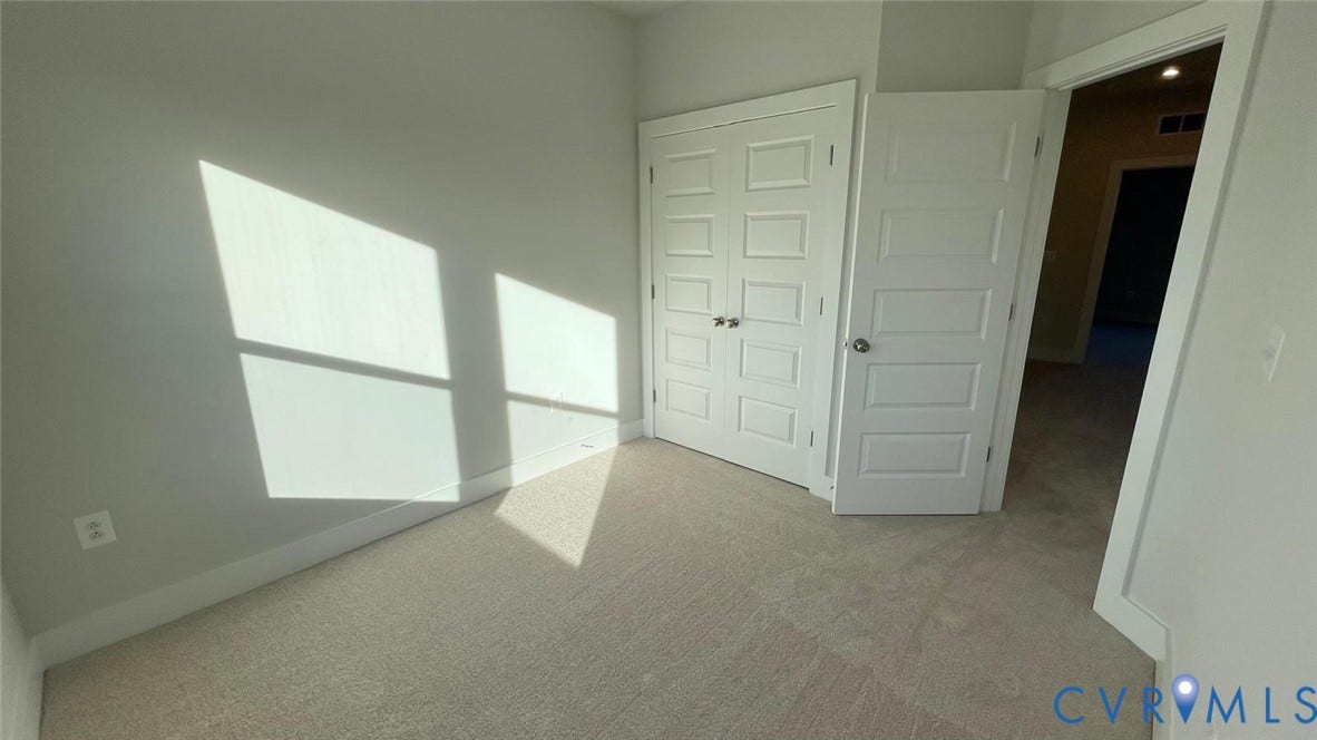 Bedroom #4 featuring light colored carpet and a closet