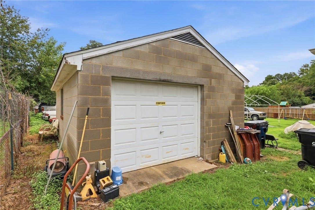 Detached garage with concrete block construction and a paneled garage door