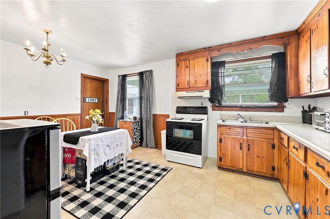 Kitchen featuring wood cabinetry, white countertops, vinyl flooring, and a white range