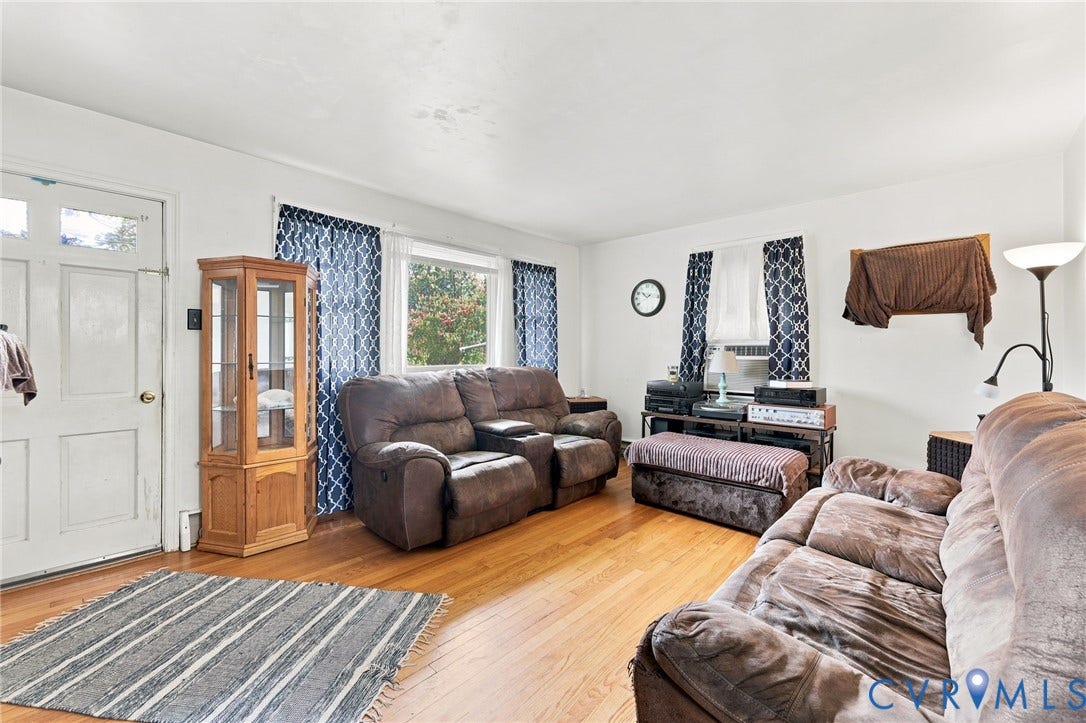 Living area featuring wood-finish flooring, white walls, and multiple windows