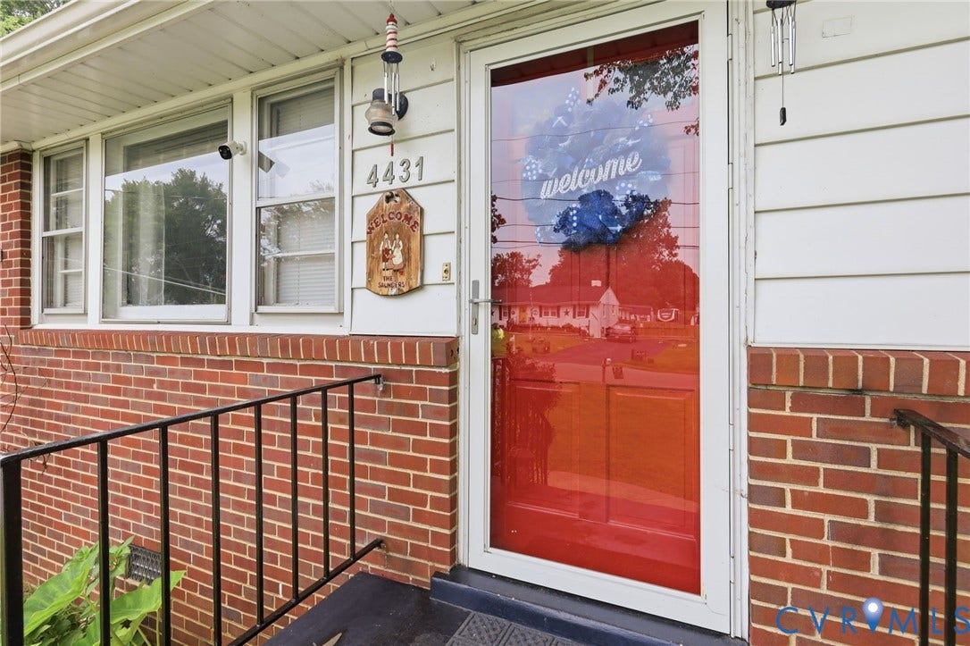 Red brick exterior with white siding and a white trim entry door