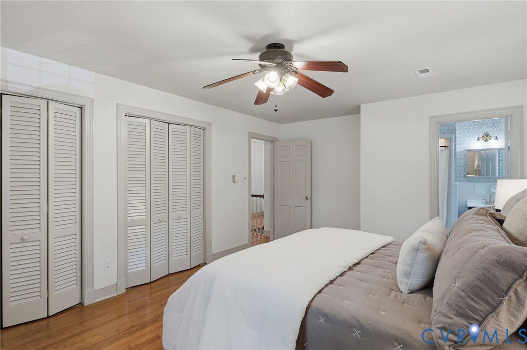 Bedroom featuring wood-finish flooring, white walls, and a ceiling fan with integrated lighting