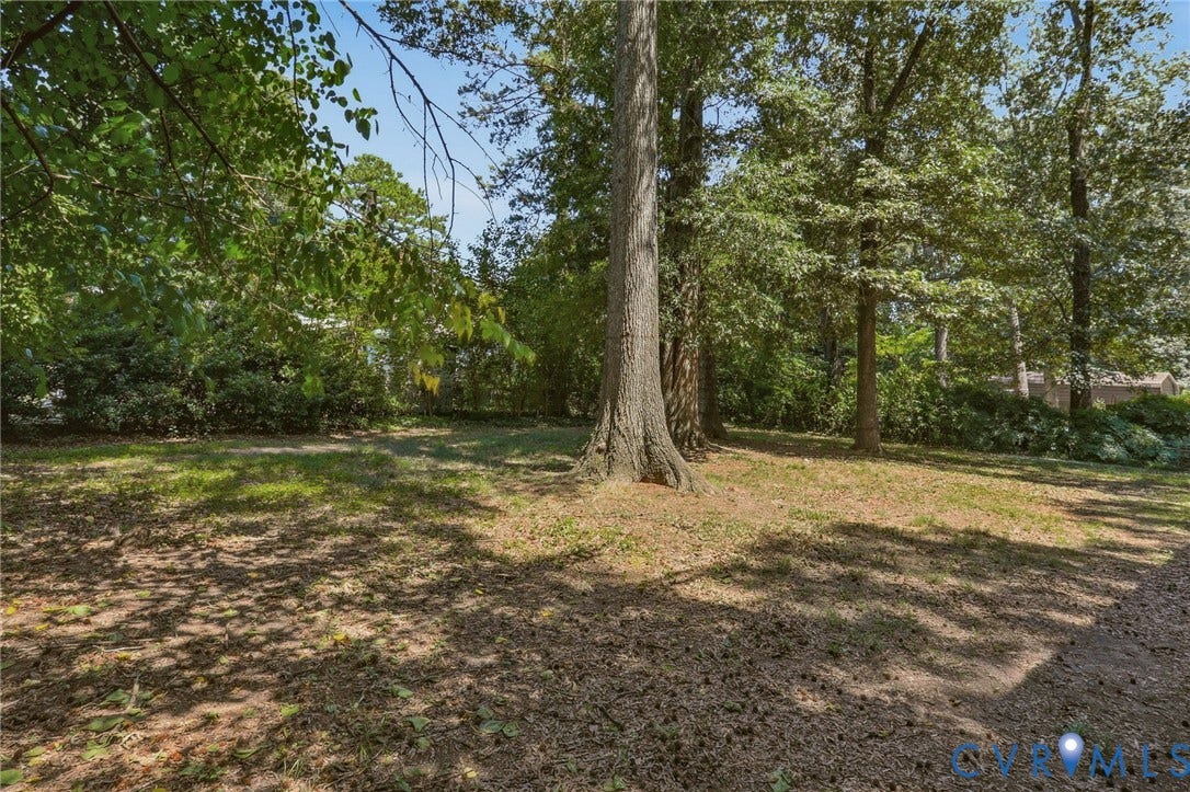 Spacious yard with mature trees providing ample shade