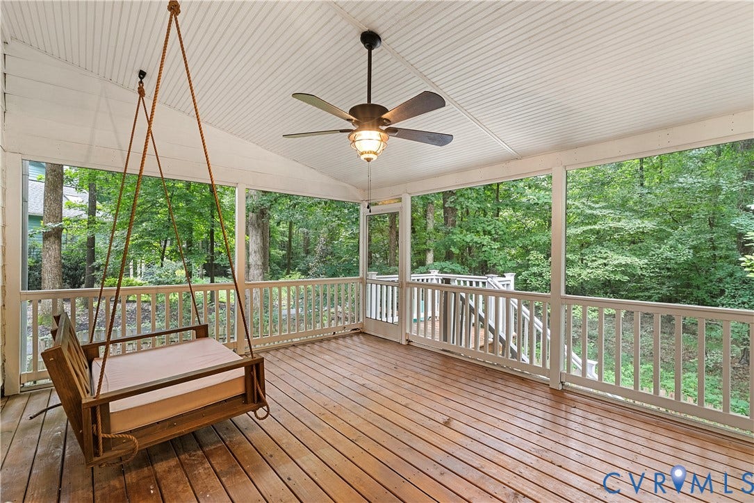 Spacious screened porch featuring wood-finish flooring, a beadboard ceiling, and a ceiling fan with integrated lighting