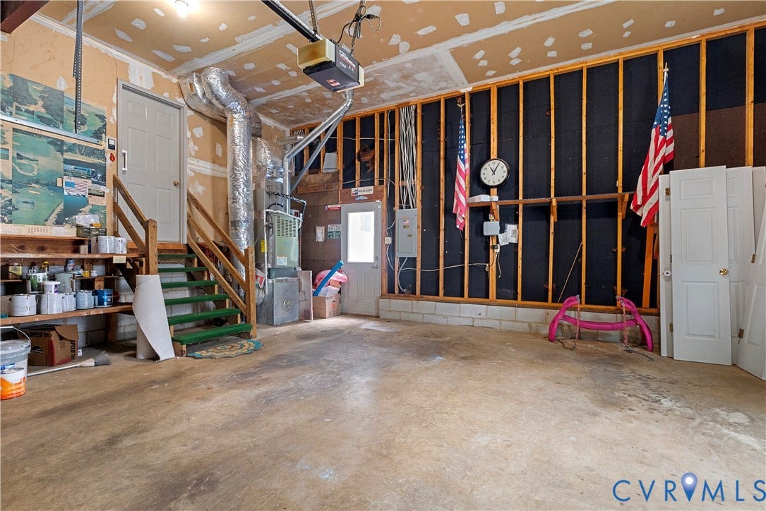 Expansive garage space featuring a concrete floor, exposed wood framing, and utility access
