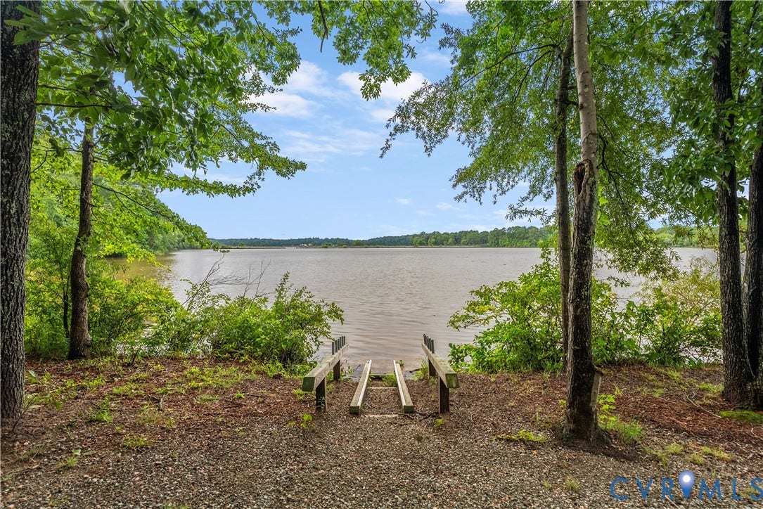Waterfront access featuring a small boat launch, surrounded by mature trees and natural foliage
