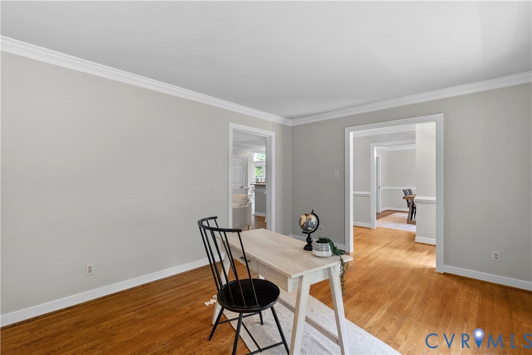 Hardwood flooring throughout, complemented by light gray wall tones and white crown molding