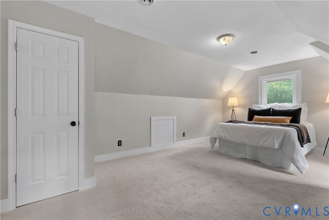 Carpeted room with a pitched ceiling and neutral wall tones
