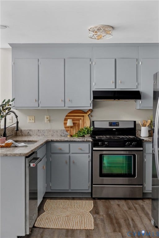Kitchen featuring light gray cabinetry, stone-finish countertops, stainless steel range with overhead ventilation, and wood-finish flooring