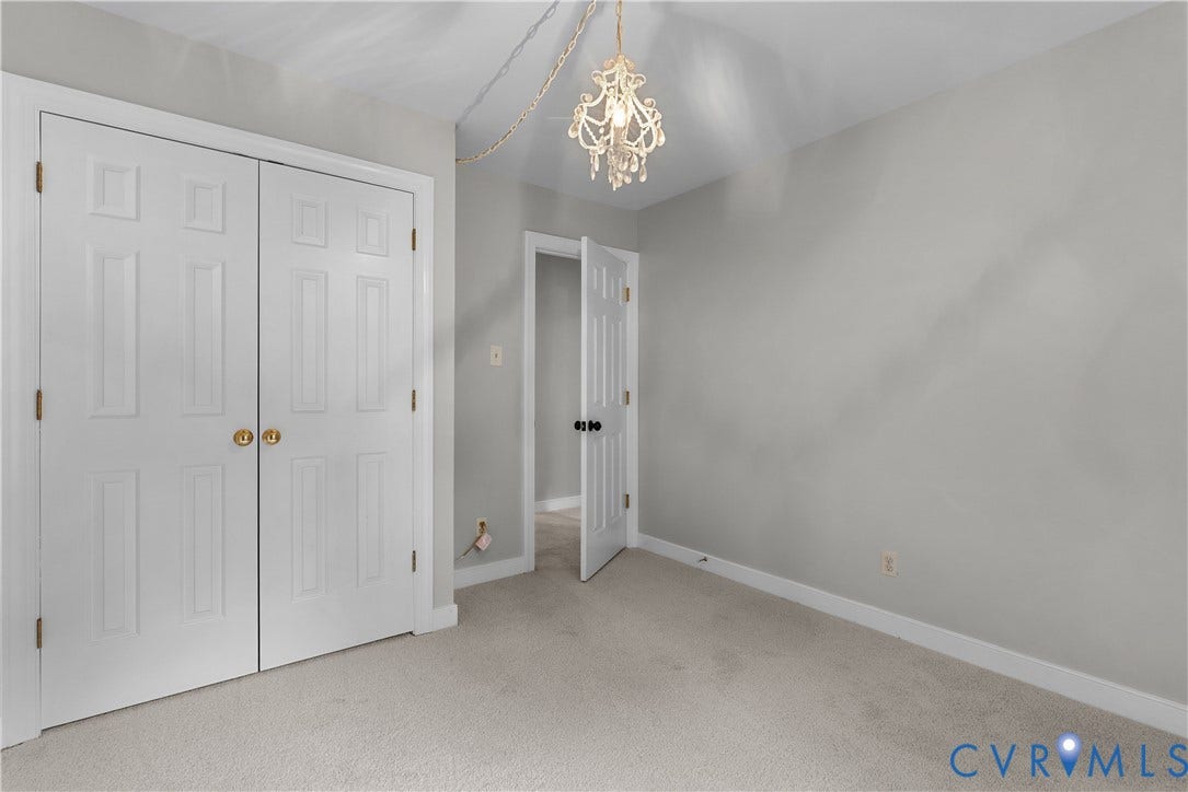 Neutral-toned room featuring a decorative chandelier with crystal accents