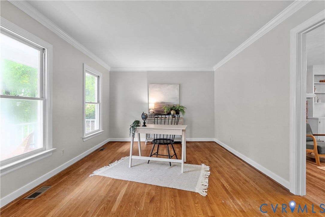 Hardwood flooring throughout, featuring crisp white trim and crown molding