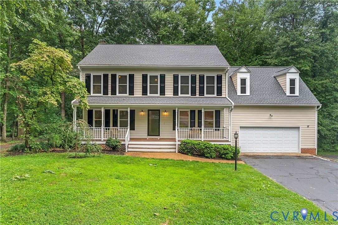 Traditional two-story residence with a covered front porch featuring white railings