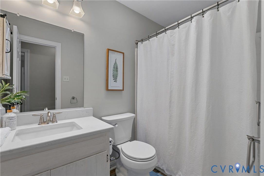 Bathroom featuring a white vanity with an integrated sink, brushed nickel faucet, and a light-colored countertop