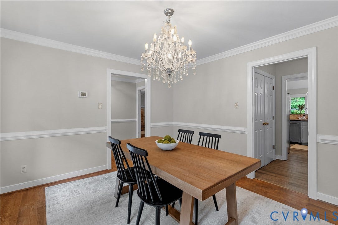 Dining area featuring a crystal chandelier, crown molding, chair rail, and wood-finish flooring