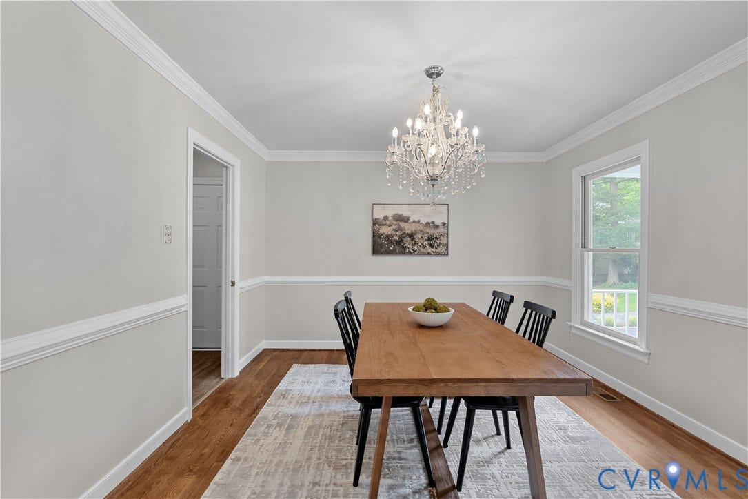 Dining space featuring wood-finish flooring, a crystal chandelier, and a single window