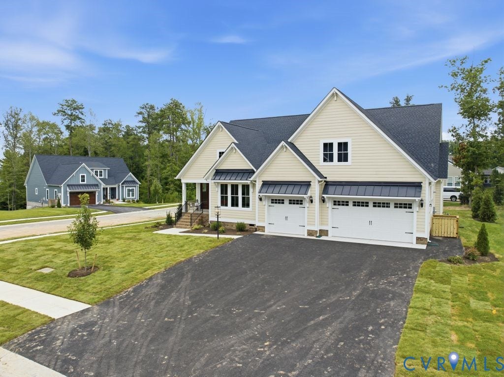 Contemporary residential exterior featuring light-colored siding and a dark shingle roof