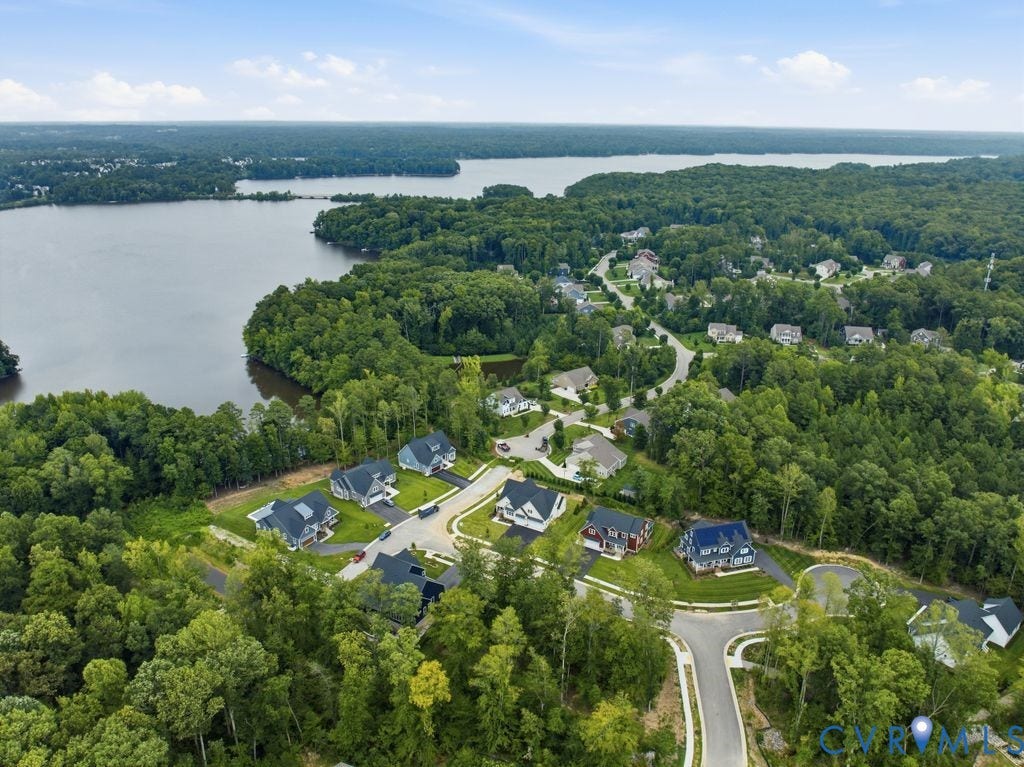 Aerial perspective showcasing a residential community surrounded by dense woodlands