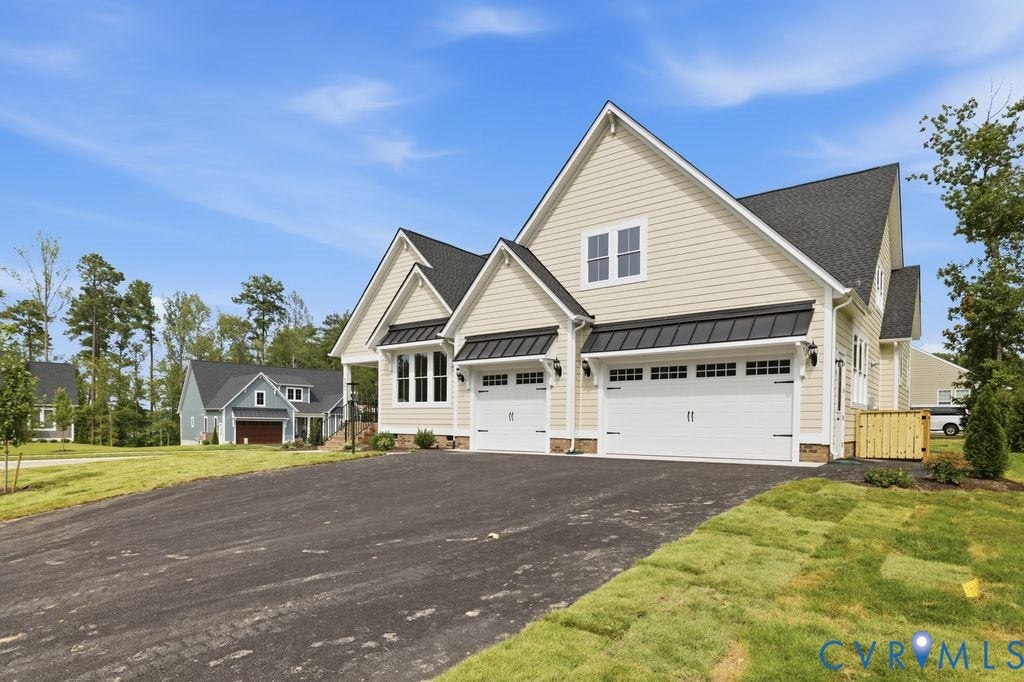 Contemporary residence featuring a light-colored siding exterior with a dark shingle roof