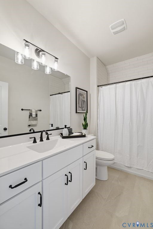 Bathroom featuring a dual-sink vanity with white cabinetry, matte black hardware, and a white countertop