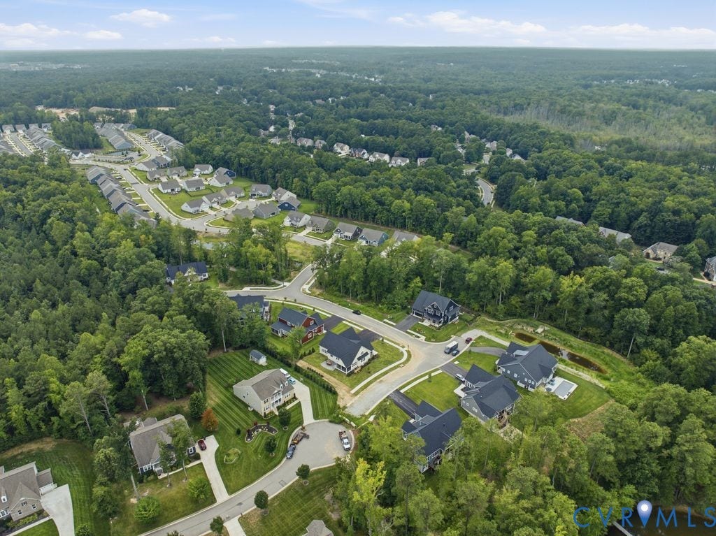 Expansive residential area featuring numerous single-family homes on individual lots, surrounded by mature trees