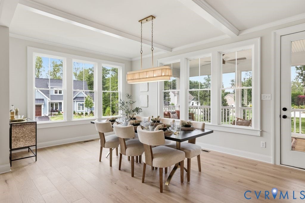 Dining area featuring light wood-finish flooring, white coffered ceiling, and a linear chandelier