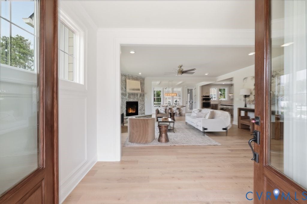 Open concept interior featuring wide plank wood-finish flooring, white trim, and recessed lighting