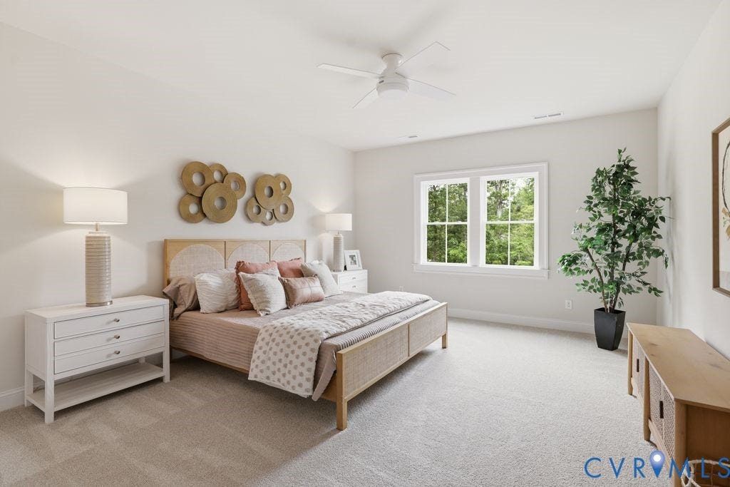 Spacious room featuring light-toned carpeting and a ceiling fan