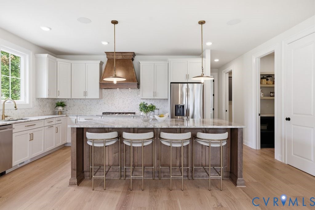 Kitchen featuring a central island with countertop, wood-finish base, and pendant lighting