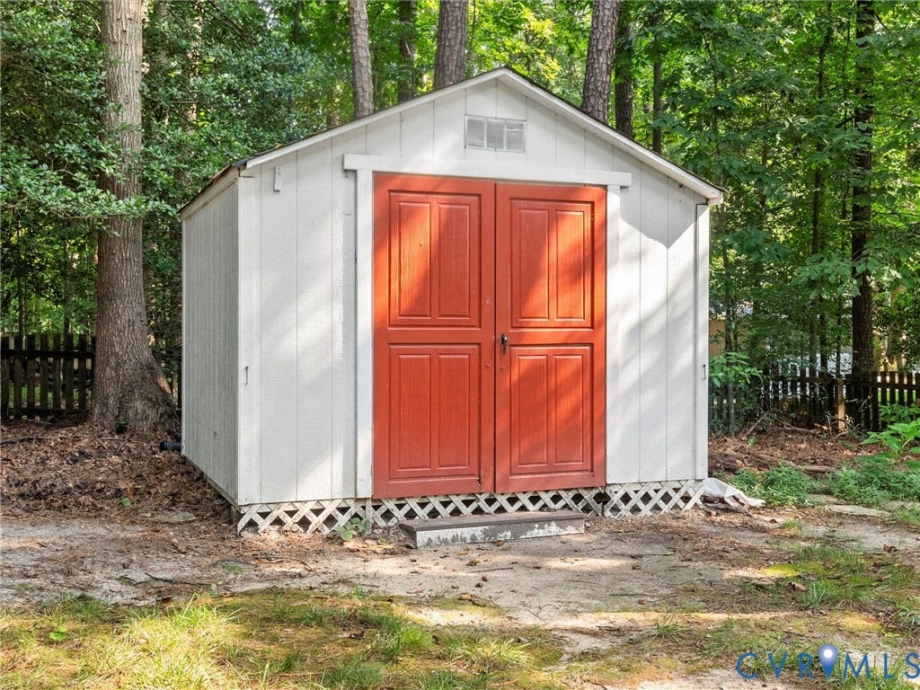 13915 Highpaige Way, Stoney Glen West, Chester, VA 23831 White storage shed with bright red double doors, a gabled roof, and lattice skirting