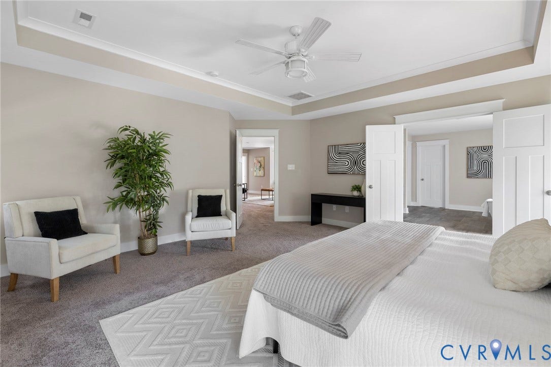 6984 Carden Park Drive, Moseley, VA 23120 Carpeted room featuring a tray ceiling, ceiling fan, and white trim throughout