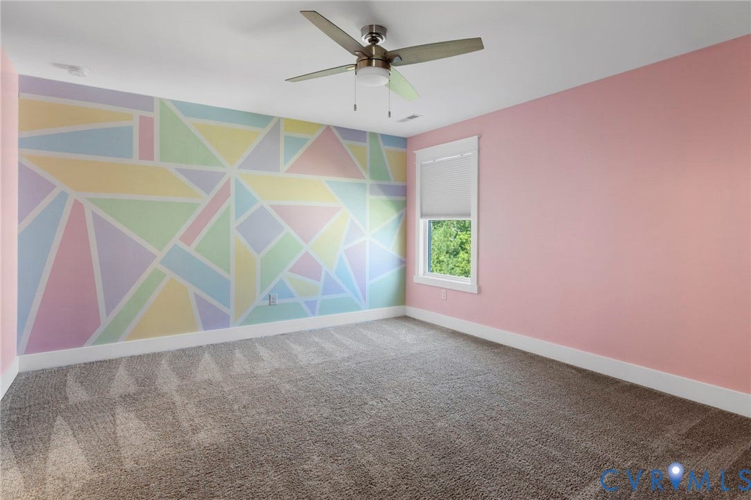6984 Carden Park Drive, Moseley, VA 23120 Spacious room featuring a ceiling fan, a window with a roller blind, and a geometric accent wall