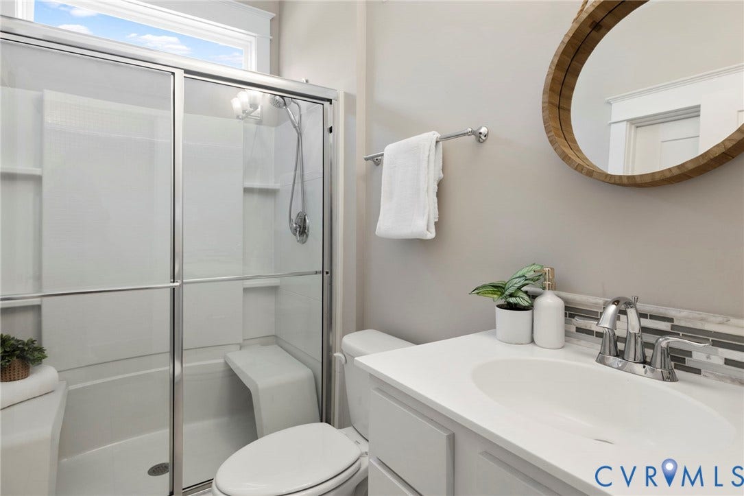 6984 Carden Park Drive, Moseley, VA 23120 Bathroom featuring a glass-enclosed shower with a built-in bench, a single vanity with an undermount sink, and a tiled backsplash